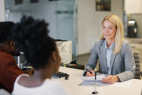 Sales rep talking to clients before signing car purchase agreement