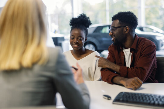 Man asking agent to draw up car purchase contract for female companion