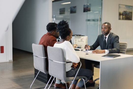 Car dealership employee talking to customers before signing contract