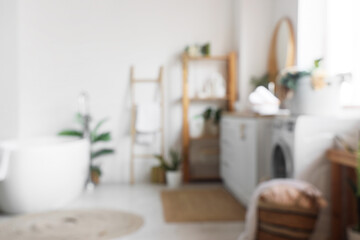 Blurred view of bathroom with washing machine, laundry baskets and sink