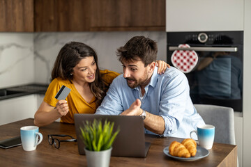 Young Couple Shopping Online Together Using Laptop and Credit Card