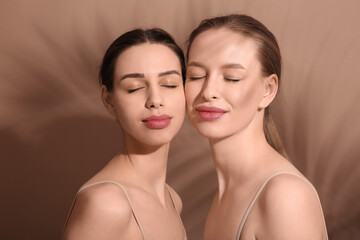 Beautiful young sisters on brown background