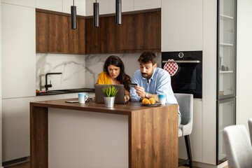 Couple Managing Finances in Modern Kitchen Together