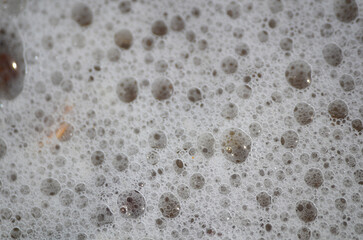 Ocean wave bubbles on sandy beach