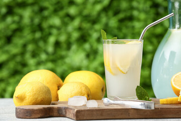 Glass of fresh lemonade with mint on grey table outdoors