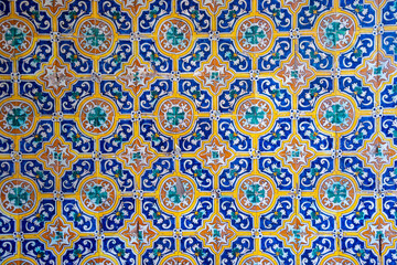 Ornamental colourful geometric medieval ceramic tiles of walls in old castle, Sevilla or Granada, Andalusia, Spain. Arabic ornament background wallpaper