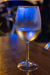 Glass of cold dry white wine served outdoor in cafe at night in historical Triana district, Sevilla, Spain, close up