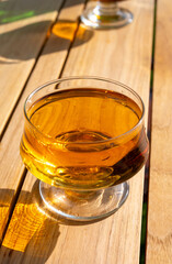 Tasting of french apple cider brut in glass made from new harvest apples outdoor in sunny orchard