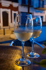Two glasses of cold dry white wine served outdoor in cafe at night in historical Triana district, Sevilla, Spain, close up