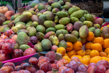 Fresh juicy colorful fruits, plums and andalusian mango tropical fruits on farmer market in Andalusia, Sevilla, Spain