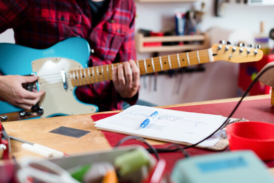 Luthier testing electric guitar after reparation