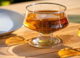 Tasting of french apple cider brut in glass made from new harvest apples outdoor in sunny orchard