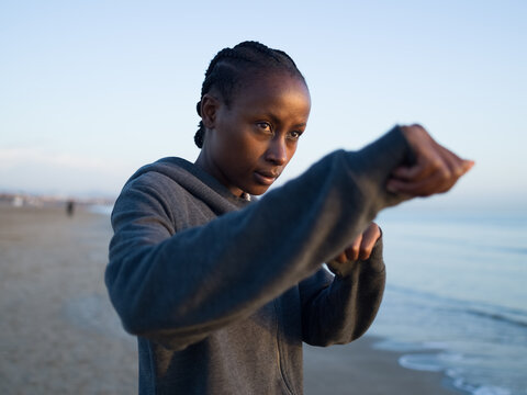 Woman practicing punches at beach