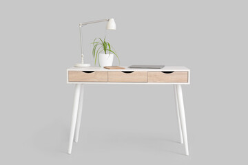 Stylish table with lamp and houseplant on white background