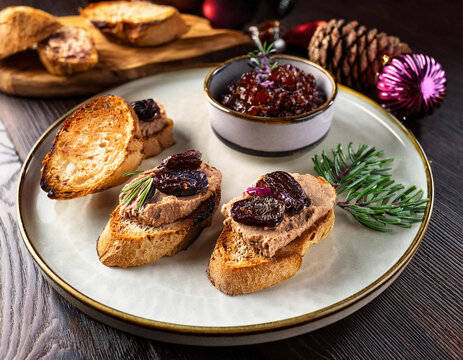 A rich duck liver p&acirc;t&eacute; served with cedar nuts, dried plums, crispy bruschetta, and a side of sweet red onion jam, creating a perfect balance of flavors and textures