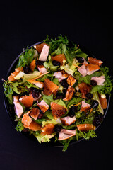 Spicy salad with smoked chicken, orange, lingonberries and lettuce. World cuisine.