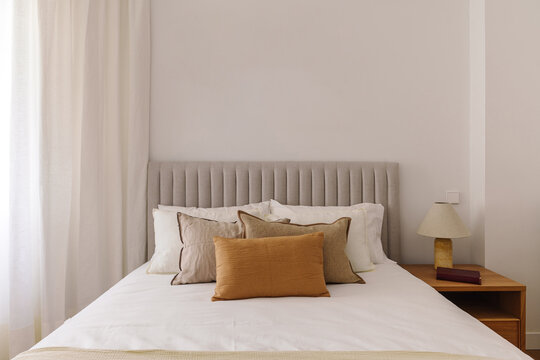 A neatly made bed with multiple pillows