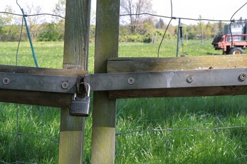 Padlock locked on old wooden fence