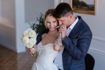 A beautiful young couple, the bride and groom, are standing in an embrace. Family. Wedding. Marriage