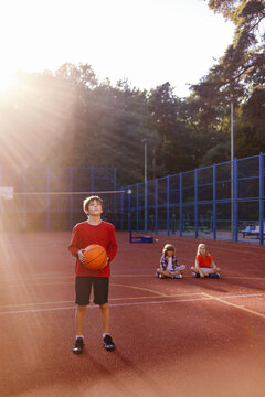 Boy showing his friends how to make two-handed basketball set shot
