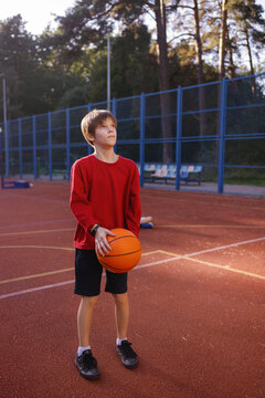 Kid practicing two-handed basketball set shots on outdoor court