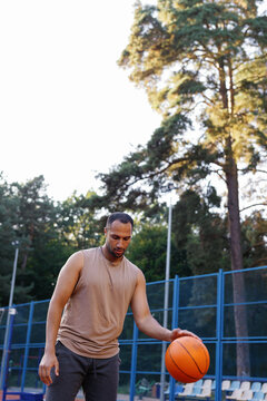 Coach practicing dribbling ball during basketball workout