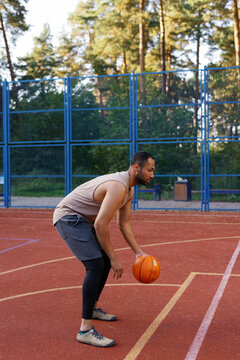 Athlete standing in dribbling stance on outdoor basketball court