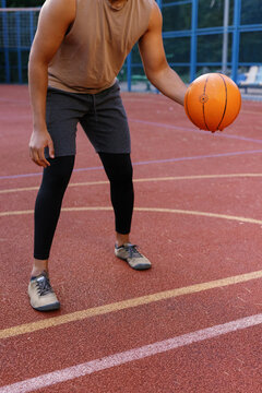 Basketball player standing in dribbling stance on outdoor court
