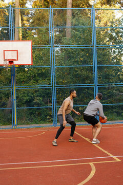 Defensive player trying to block opponent basketball shot during game