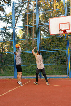 Defender trying to block basketball shot of offensive player