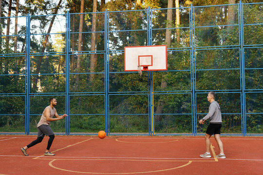 Athlete passing ball to coach during training on basketball court