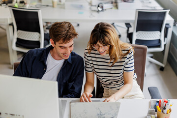 Colleagues working together on laptop in office