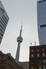 Fototapeta premium abstract view of CN Tower framed by old and new buildings (photo taken at York St and University Av looking southwest) in downtown Toronto, Canada