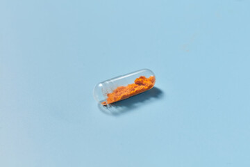 Orange coloured dust placed inside of transparent capsule