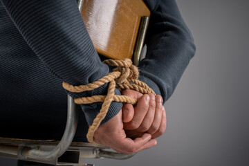 kidnapped man's hands tied with rope, criminal concept