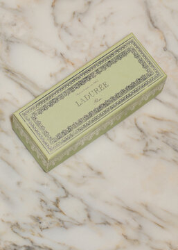 green Laduree Paris macaron box for six macarons on white marble table