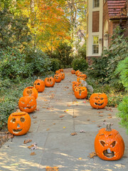 Row of Carved Pumpkin faces decorated alongside home