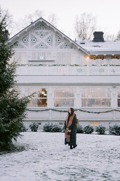 Person gazing at decorated white house in winter