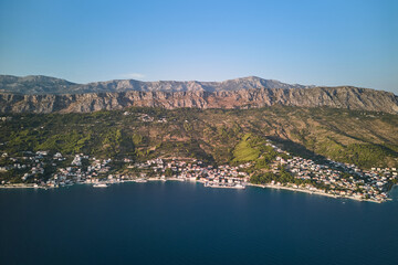 Aerial view of the Adriatic Sea coastline with small villages at the foot of the mountain range in Croatia