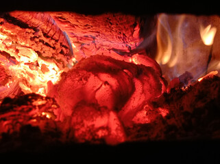 Wood burning in the dark, a small fire . Gas and wood burning stoves in the village are dangerous . Gas and wood are burned together in the stove.
