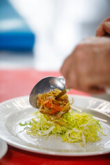 A chef is placing a lettuce in a plate