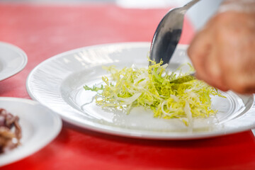A chef is placing a lettuce in a plate