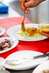 A chef is placing a lettuce in a plate