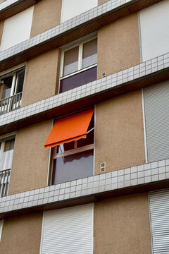 Bright orange awning extending from a modern apartment window