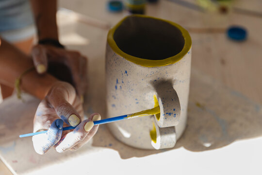 Close-Up of Artist Painting Ceramic Pitcher Handle