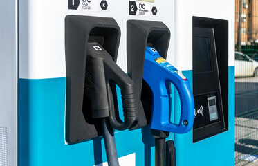 Close up of ccs and chademo charger connectors in an EV electric vehicle fast charging station.