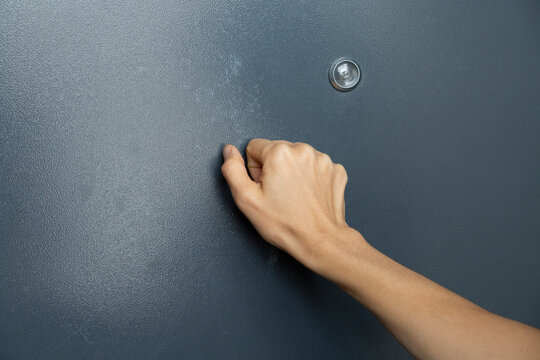 Hand Knocking on a Metal Door