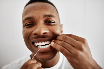 Happy, black man or portrait with dental floss for teeth cleaning, cavity or healthcare hygiene at home. Face, young African or male person with smile or pov for tooth, oral or mouth care in bathroom