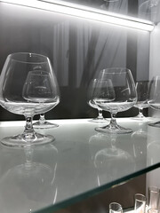Glass cabinet with different glasses and glasses, all illuminated by built-in lighting