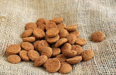 Ginger nuts or pepernoten, a traditional Dutch december sweet, on jute.